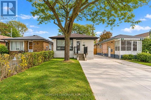 A tree in front of a house with a sign that says "HomeLife Landmark Realty, Inc. Brokerage".