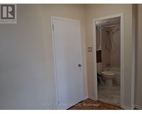 A bathroom with a toilet and a shower.