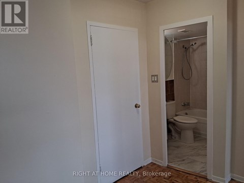 A bathroom with a toilet and a shower.
