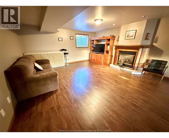 A living room with a brown couch and a fireplace.
