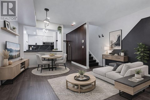 A modern living room with a kitchen area in the background.