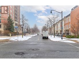 A street with a truck driving down it and buildings on either side.