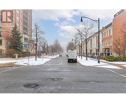 A street with a truck driving down it and buildings on either side.
