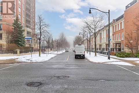A street with a truck driving down it and buildings on either side.