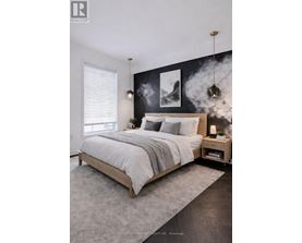 A bedroom with a large bed and a black and white artwork on the wall.