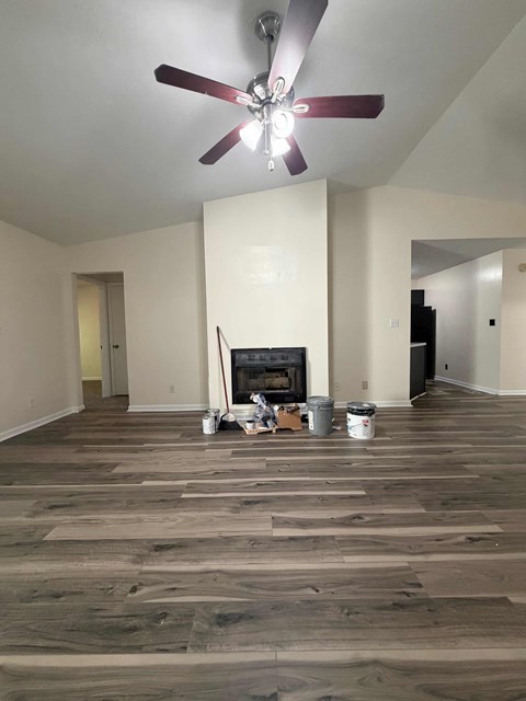 A room with a fireplace and a ceiling fan.
