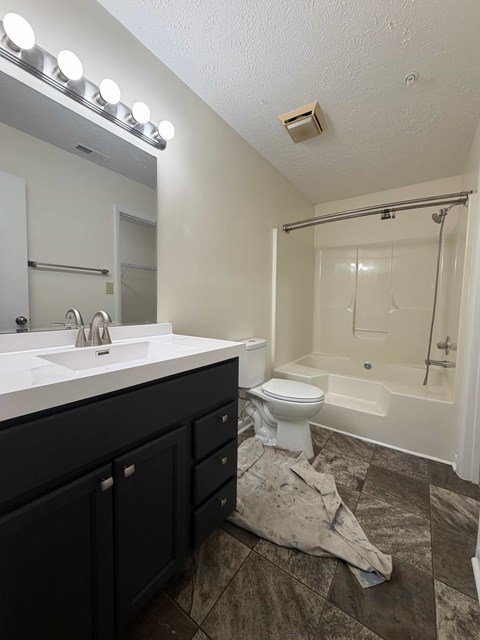 A bathroom with a white sink and a white toilet.