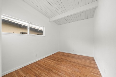 Empty room with wooden floor and white walls.