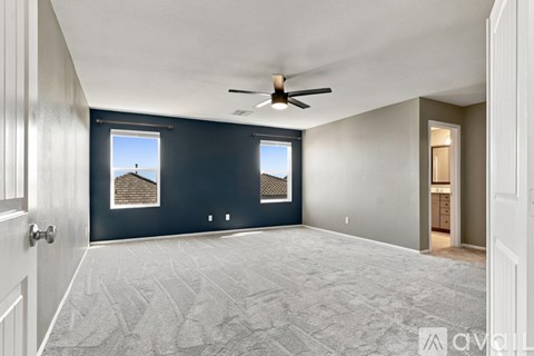 A spacious room with a ceiling fan and carpeted floor.