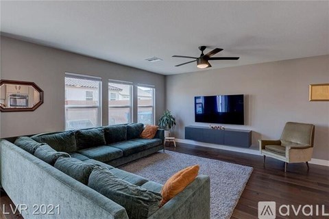 A living room with a grey couch and a television.