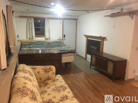 A bedroom with a bed, a couch, and a fireplace.