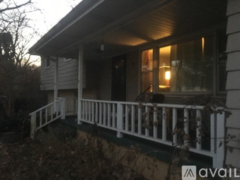 A house with a porch and a lit window.