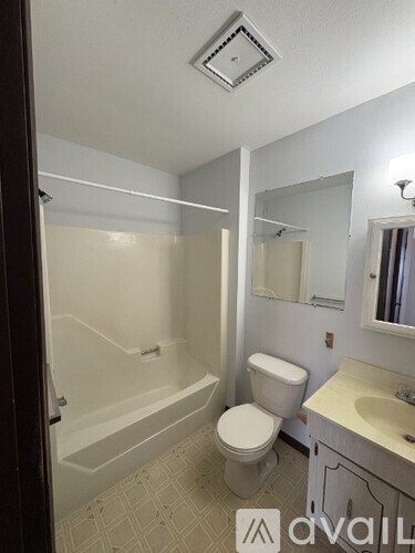 A bathroom with a toilet, sink, and bathtub.