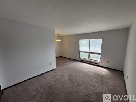 A room with a window and carpeted floor.