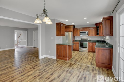 A kitchen with wooden cabinets and a stainless steel refrigerator.