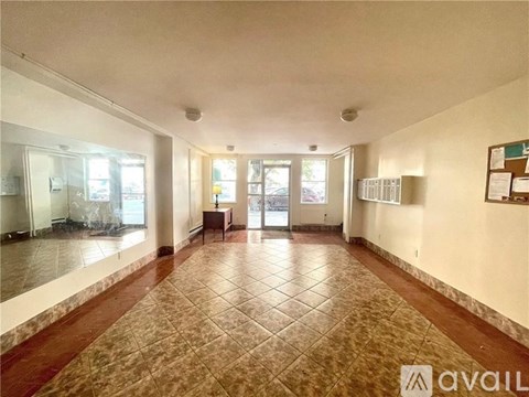 A spacious room with a tiled floor and a bulletin board on the wall.