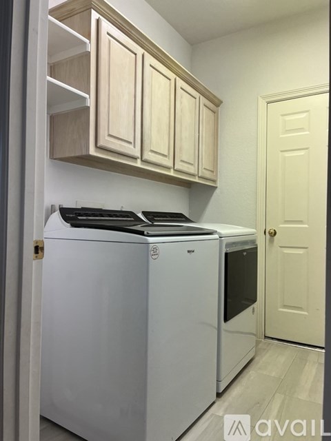 A white fridge and oven in a kitchen with wooden cabinets.