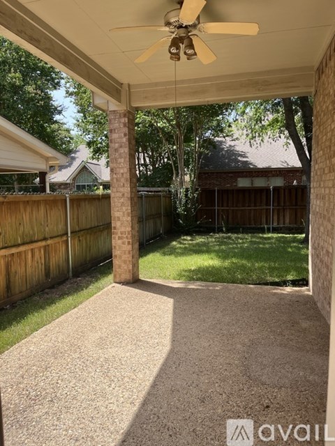 A patio with a ceiling fan and a concrete floor.