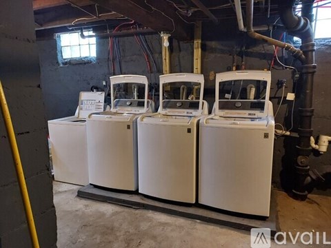 Three identical white machines are lined up in a room.