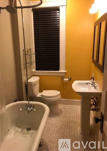 A bathroom with a yellow wall and a white bathtub.