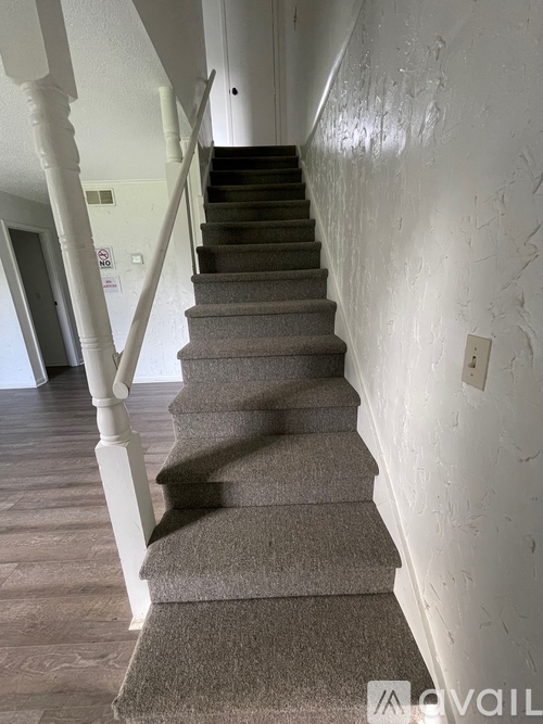 A staircase with a carpeted runner and white balusters.