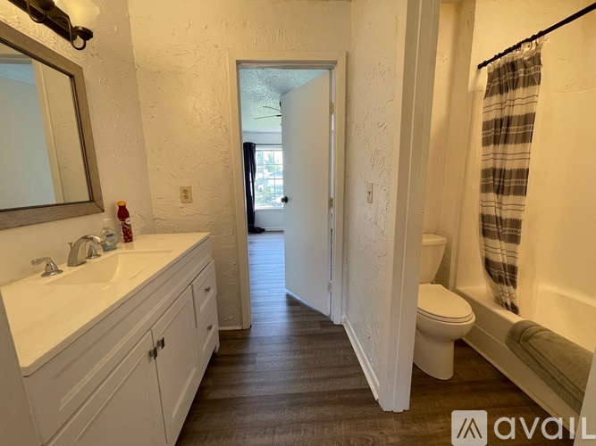 A bathroom with a toilet, sink, and mirror.