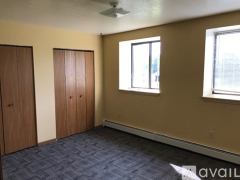 A room with a ceiling fan and two doors.