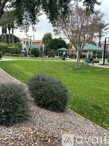 A park with a gravel path and green grass.