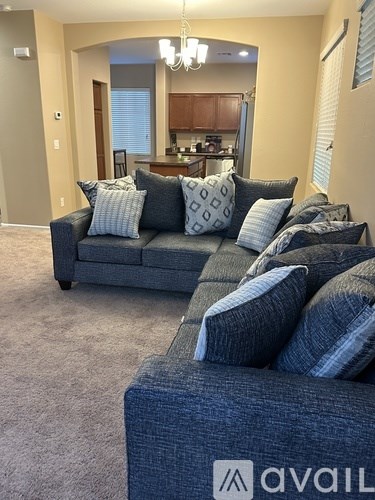 A living room with a grey couch and a grey ottoman.
