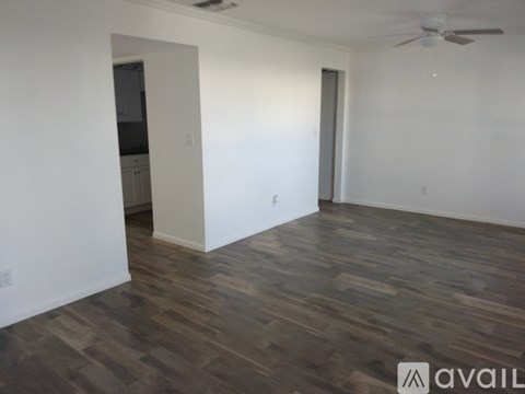 A room with wooden flooring and a ceiling fan.