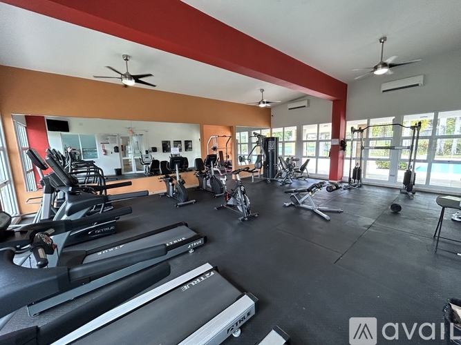 A gym with a variety of equipment including treadmills, weights, and exercise machines.