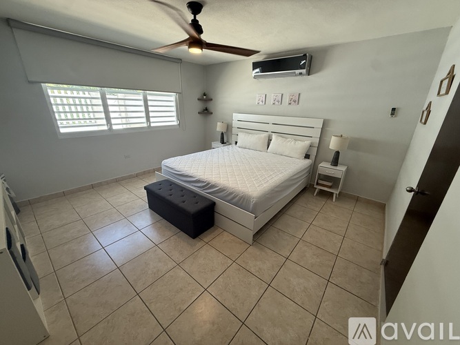 A bedroom with a bed, nightstand, and a ceiling fan.