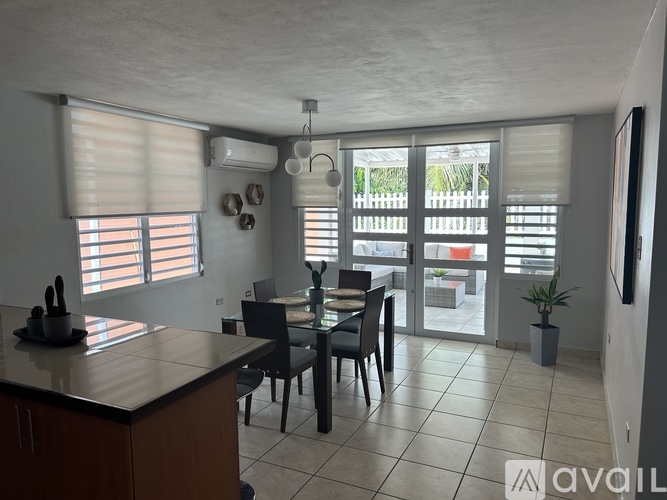 A kitchen with a table and chairs in front of a window with blinds.