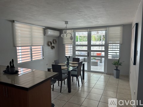 A kitchen with a table and chairs in front of a window with blinds.