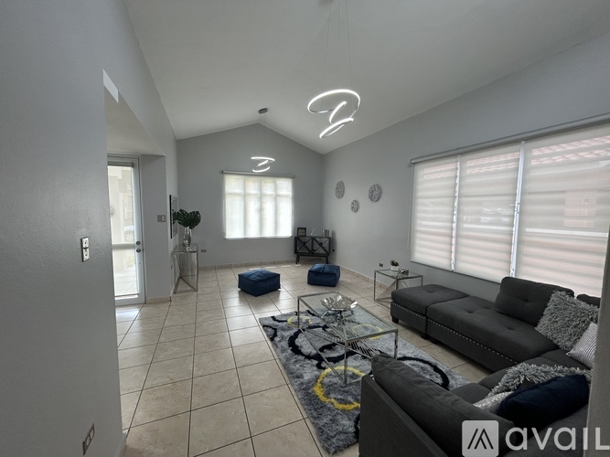 A living room with a grey sofa and a glass coffee table.