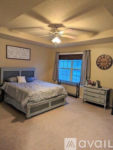 A bedroom with a bed, dresser, and window.