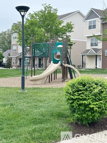 A playground with a green slide and a brown slide.