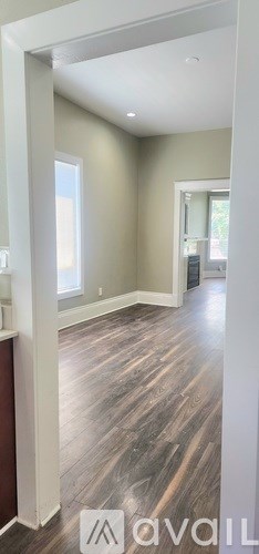 A room with wooden flooring and a white column.