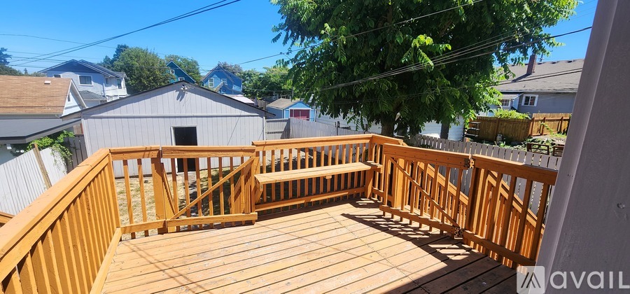 A wooden deck with a bench and railing.