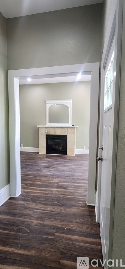 A room with a fireplace and wood flooring.