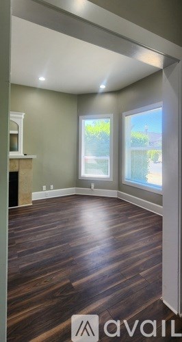 A room with wooden floors and a large window.
