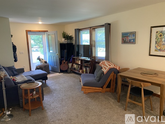 A living room with a couch, chair, and a guitar.