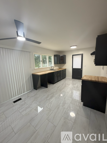 A modern kitchen with a ceiling fan and a countertop.