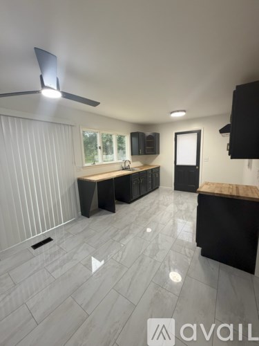 A modern kitchen with a ceiling fan and a countertop.