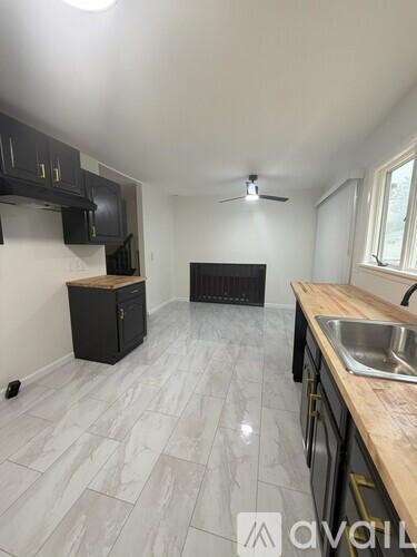 A kitchen with black cabinets and a wooden countertop.