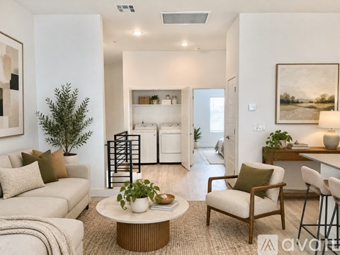 A living room with a white couch, a coffee table, and a painting on the wall.