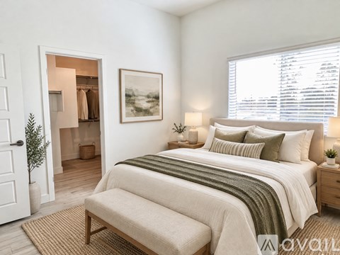 A bedroom with a large bed and a painting on the wall.