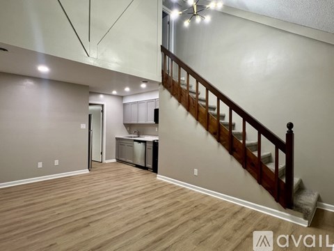 A room with wooden floors and a staircase leading to the upper level.