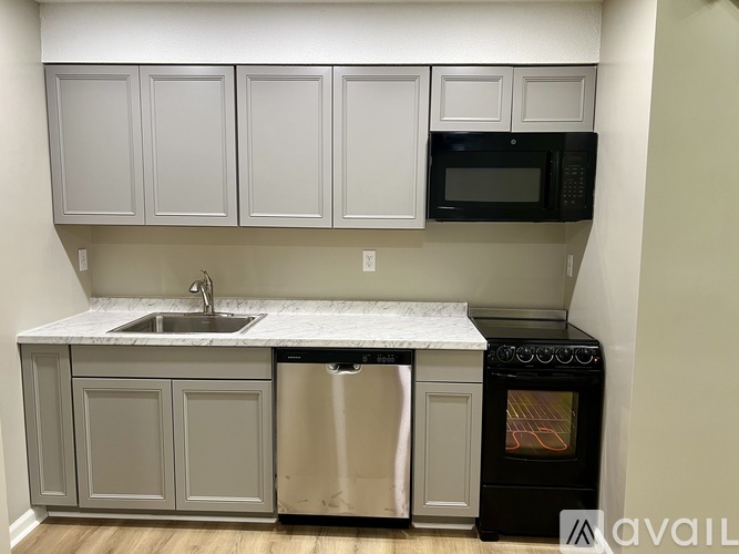 A kitchen with a sink, dishwasher, oven and microwave.