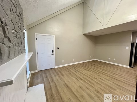 A room with a white door and wooden flooring.